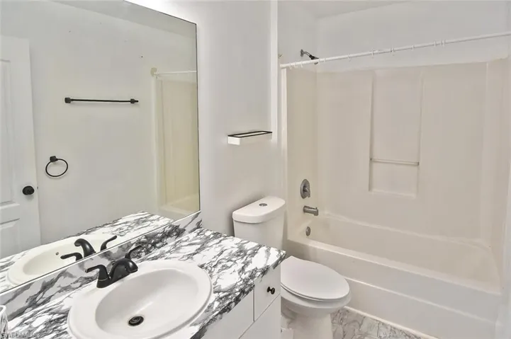 Full bathroom featuring tile flooring, vanity, toilet, and tub / shower combination