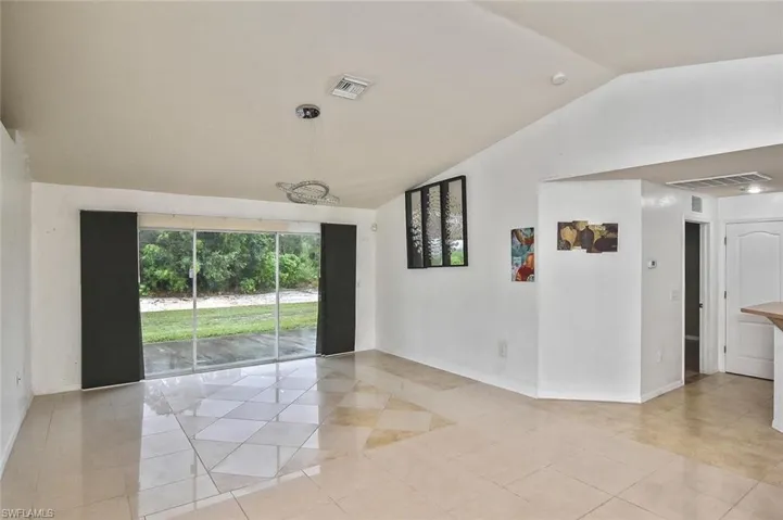 Tiled spare room with vaulted ceiling