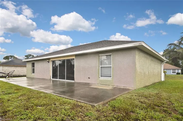 Back of property featuring a yard and a patio