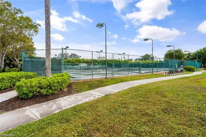 View of tennis court featuring a lawn