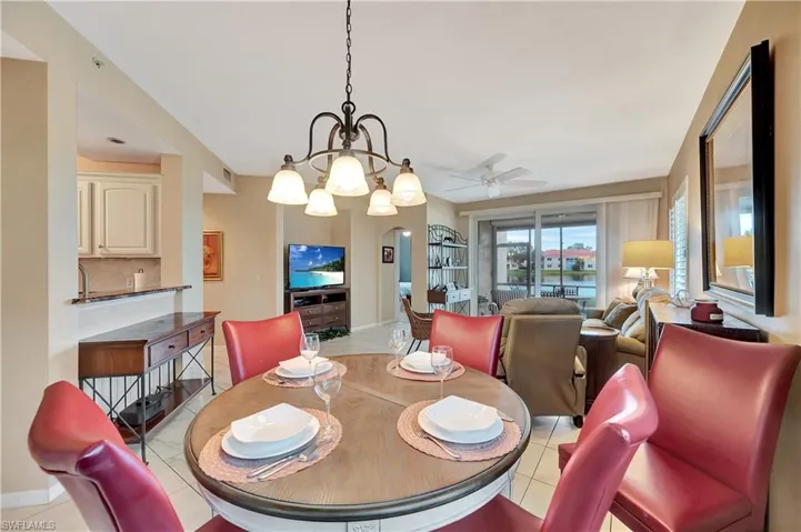 Tiled dining room with ceiling fan with notable chandelier