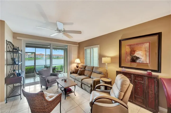 Tiled living room featuring a water view and ceiling fan