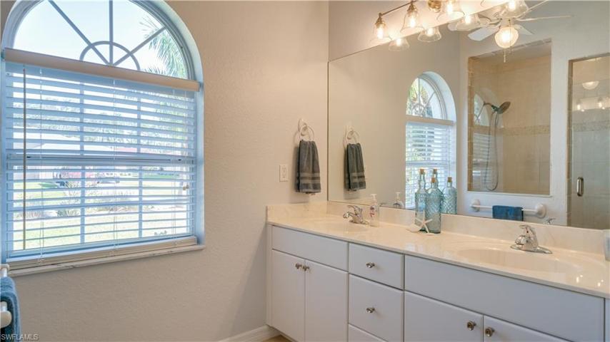 The master bathroom offers dual sinks and bright cabinetry.