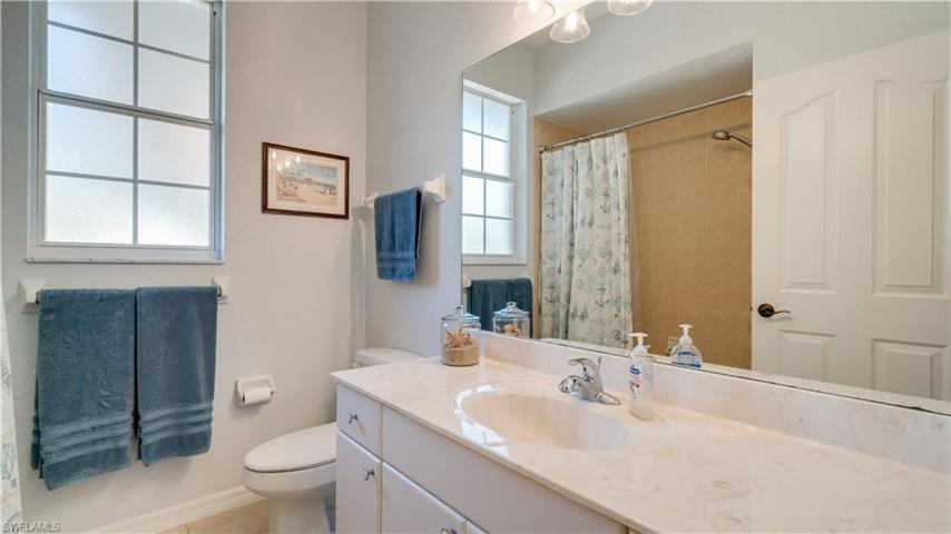 A tub and shower combo, featuring lovely sparkling tile, offers convenience and comfort.