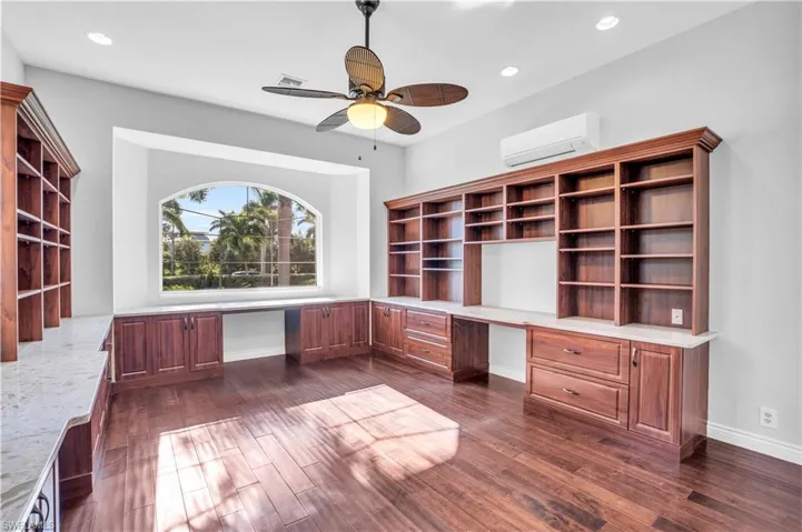 Office featuring built in desk, ceiling fan,