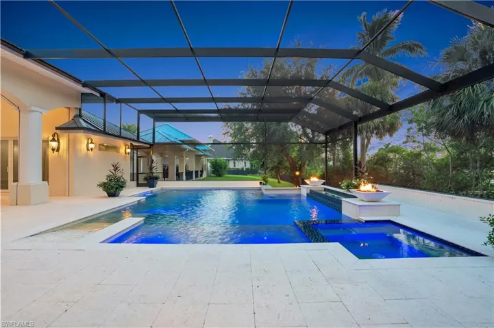 View of pool featuring pool water feature, a lanai, a patio, and an in ground hot tub