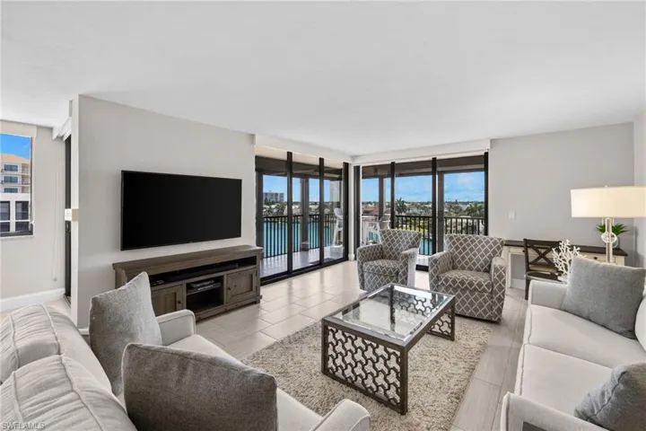 Spacious living area featuring large format tile flooring and extensive sliding glass doors