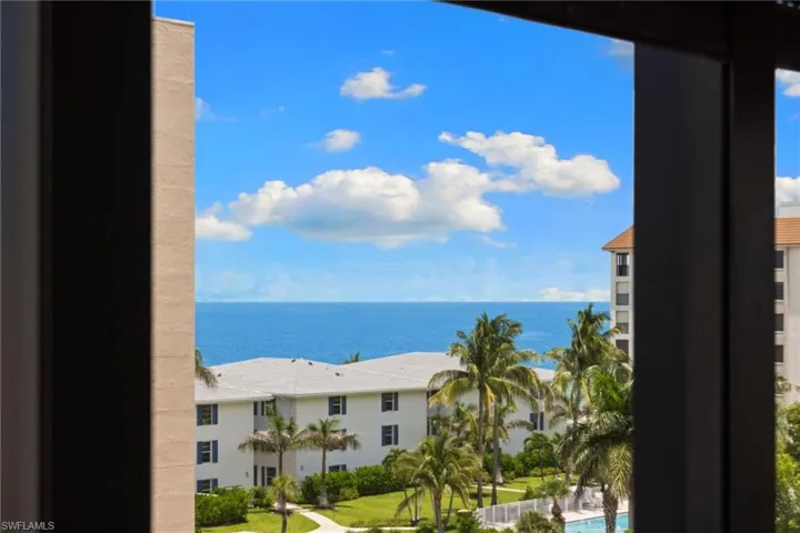Expansive ocean scenery with a vibrant blue sky and scattered white clouds