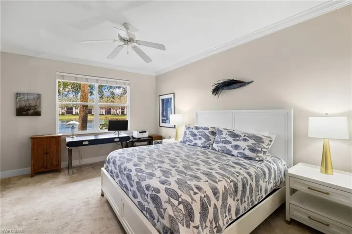Bedroom with ceiling fan, crown molding, baseboards, and light carpet