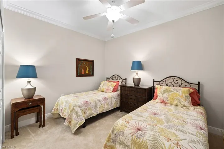 Bedroom featuring a ceiling fan, crown molding, carpet, and baseboards