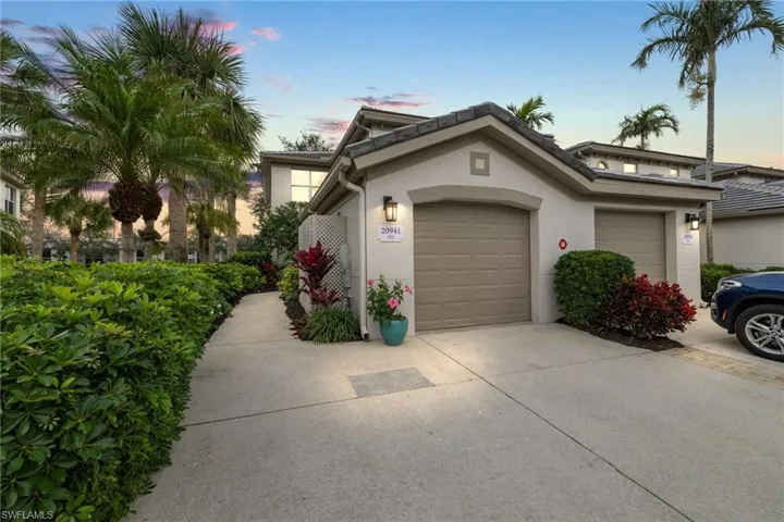View of front of house with stucco siding, an attached garage, and concrete driveway