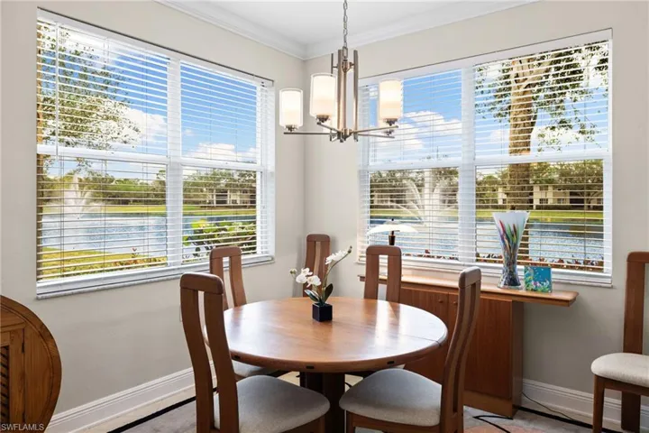 Dining area with a notable chandelier, crown molding, and baseboards
