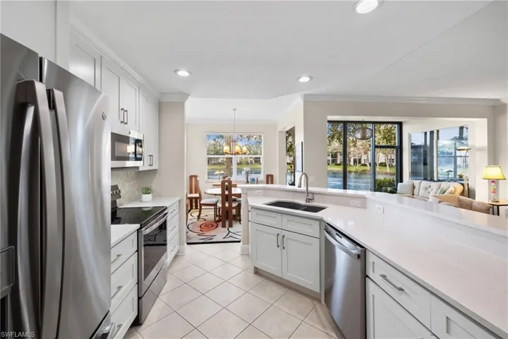 Kitchen with a notable chandelier, appliances with stainless steel finishes, crown molding, and a sink