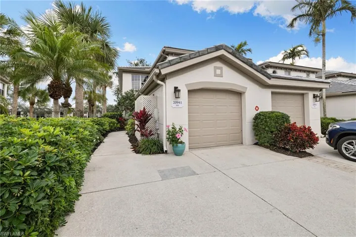 View of front of house with stucco siding, concrete driveway, and an attached garage