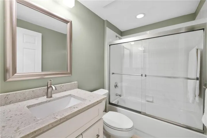 Full bath with vanity, toilet, recessed lighting, and shower / bath combination with glass door