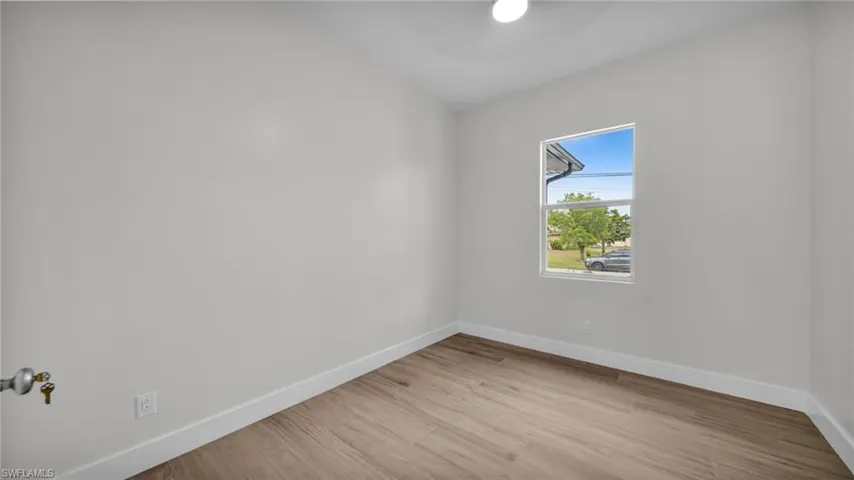 Spare room featuring baseboards and light wood finished floors