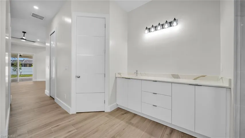 Bathroom featuring double vanity, light wood-type flooring, and recessed lighting