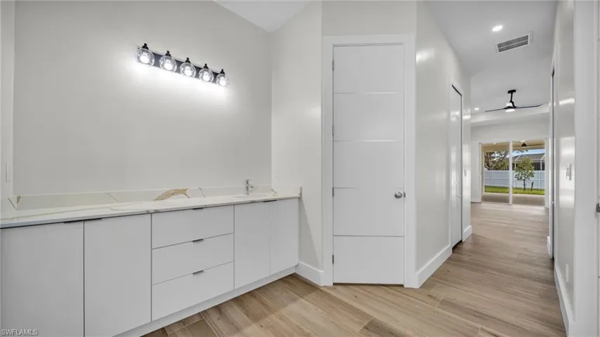 Bathroom featuring double vanity, light wood-style floors, a ceiling fan, and recessed lighting