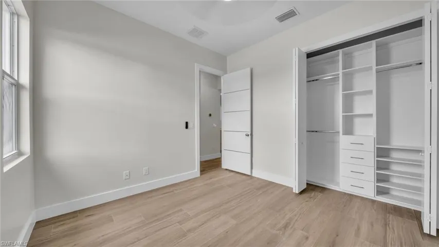 Unfurnished bedroom with light wood-type flooring and a closet