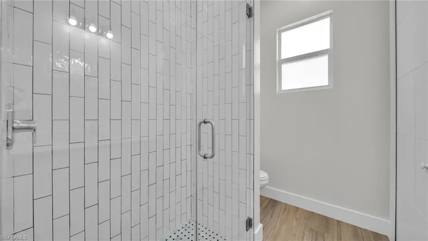 Full bath with a stall shower and light wood-type flooring