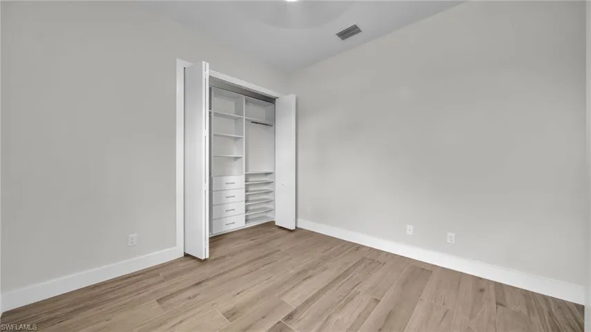Unfurnished bedroom with light wood-style floors and a closet
