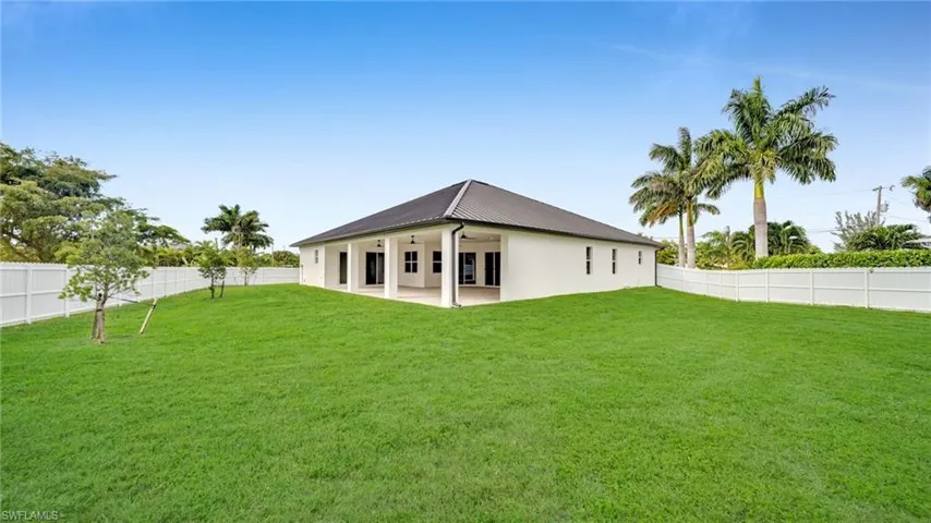 Back of property with a patio, a fenced backyard, a ceiling fan, and a metal roof