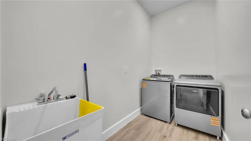 Washroom with light wood finished floors and separate washer and dryer