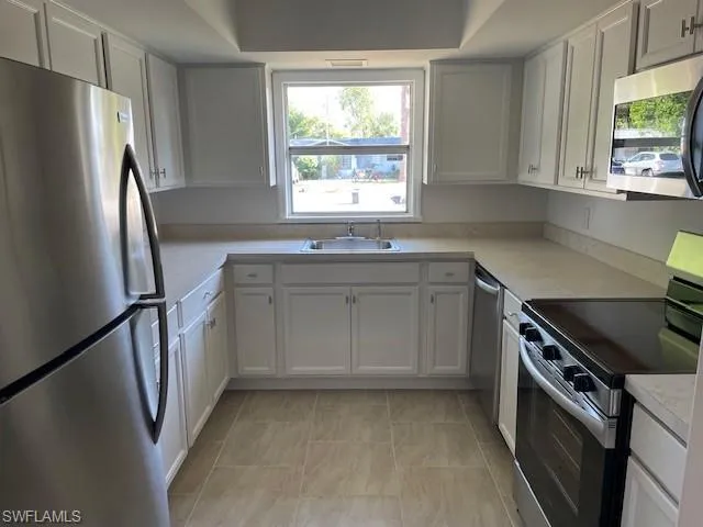 Kitchen with stainless steel appliances, a sink, and light countertops