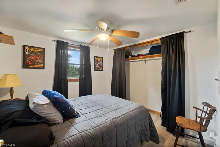 Bedroom with a closet, wood-type flooring, and ceiling fan