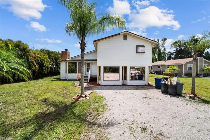 Rear view of property with a lawn