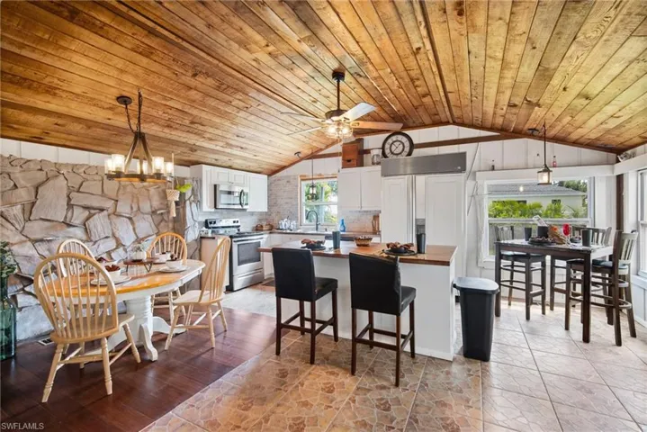 Kitchen with a healthy amount of sunlight, range, lofted ceiling, and tasteful backsplash