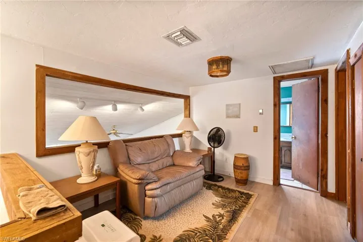 Living room with ceiling fan and hardwood / wood-style flooring