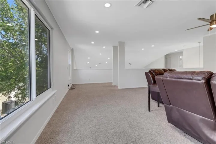 Living area featuring visible vents, light carpet, recessed lighting, baseboards, and ceiling fan