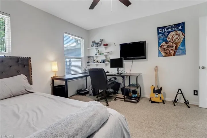 Carpeted bedroom featuring a ceiling fan and baseboards