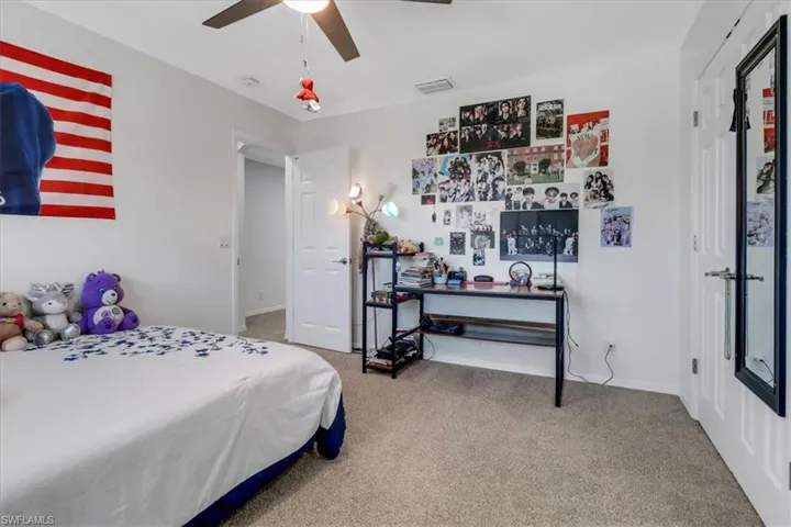 Bedroom with visible vents, baseboards, ceiling fan, and carpet flooring