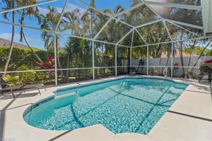 View of swimming pool with a fenced in pool, fence, a lanai, and a patio area