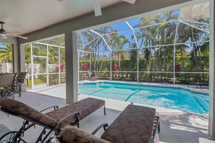 View of swimming pool with a fenced in pool, a lanai, a ceiling fan, and a patio area