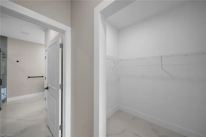 Spacious closet with light marble finish floors