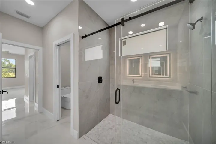 Bathroom featuring a marble finish shower and marble finish flooring
