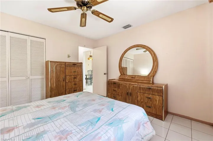Bedroom with a closet, ceiling fan, and tile patterned floors