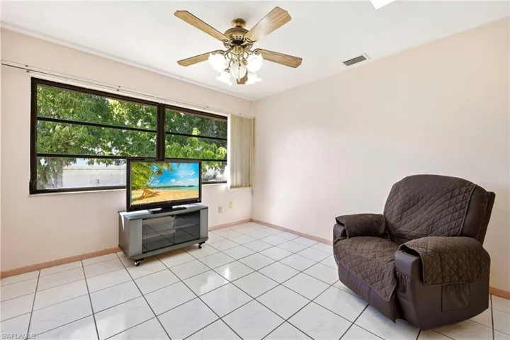 Sitting room with light tile patterned floors and ceiling fan