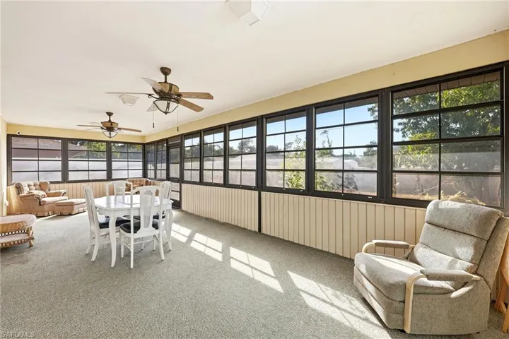 Sunroom / solarium with an outdoor hangout area, outdoor dining area, carpet floors, and a ceiling fan