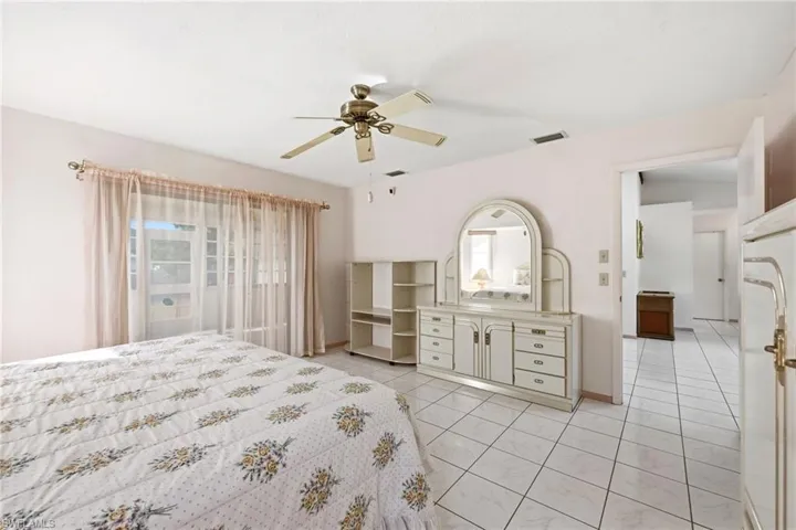 Bedroom with a ceiling fan and multiple windows