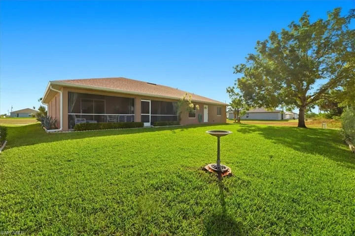 Rear view of property with a yard and a sunroom