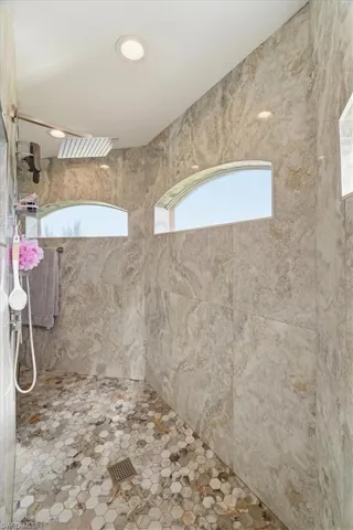Full bathroom with tiled shower and recessed lighting