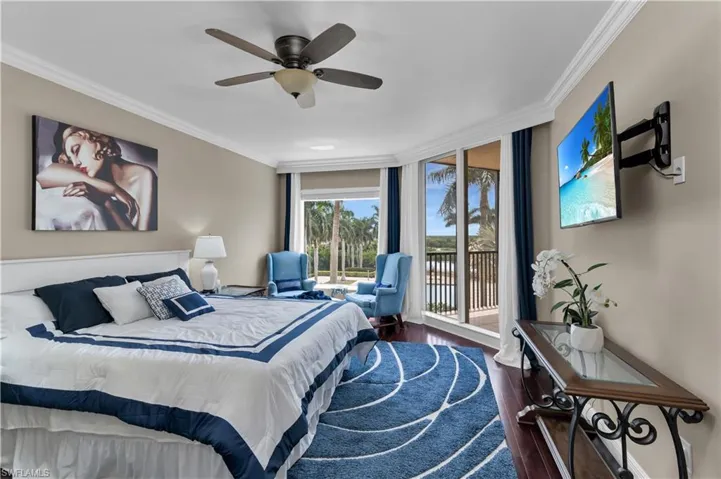 Bedroom with ornamental molding, wood finished floors, floor to ceiling windows, access to exterior, and ceiling fan