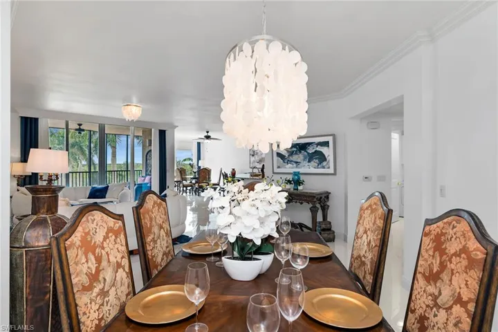 Dining space with a chandelier, crown molding, and ceiling fan