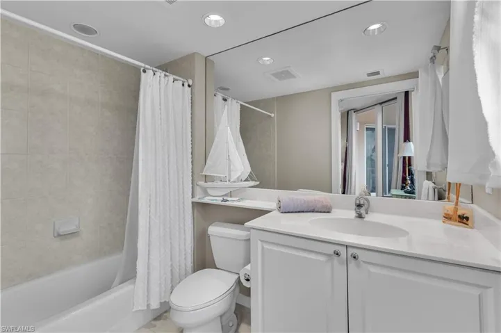 Bathroom with vanity, shower / tub combo, and recessed lighting