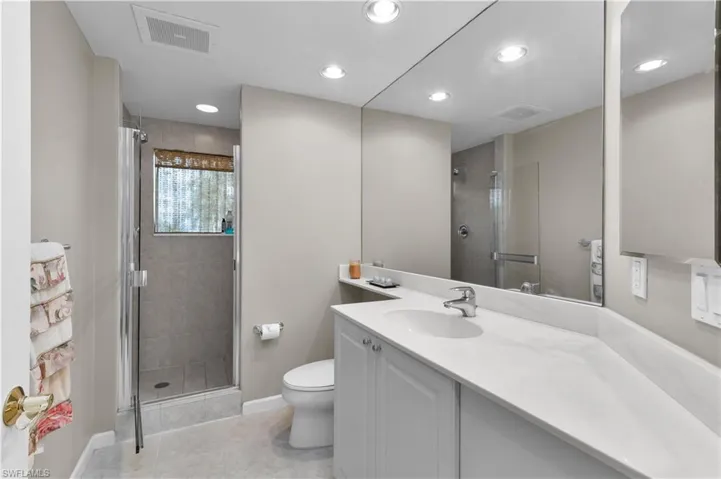 Full bathroom with a shower stall, vanity, tile patterned floors, and recessed lighting