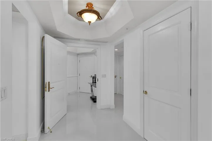 Hall featuring a tray ceiling and crown molding